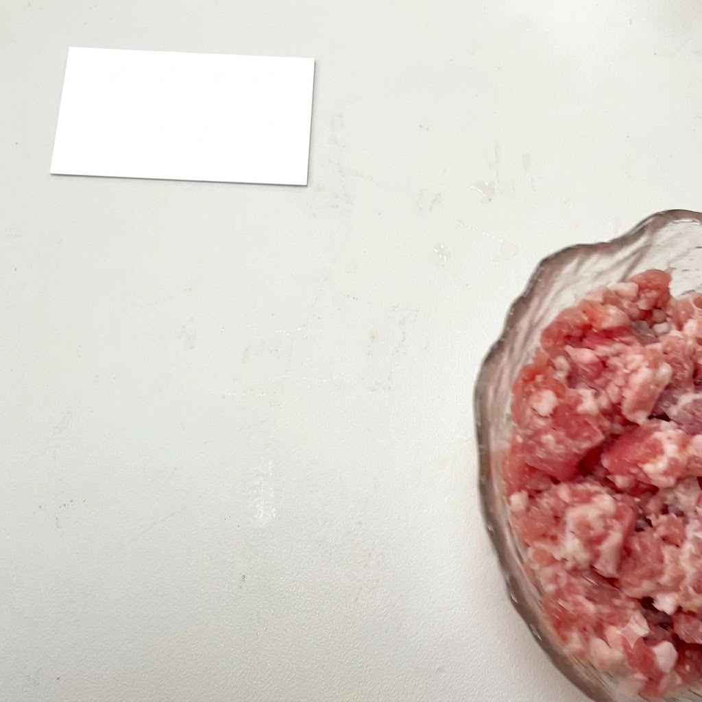 Viande hachée dans un bol en verre avec des assaisonnements ajoutés.