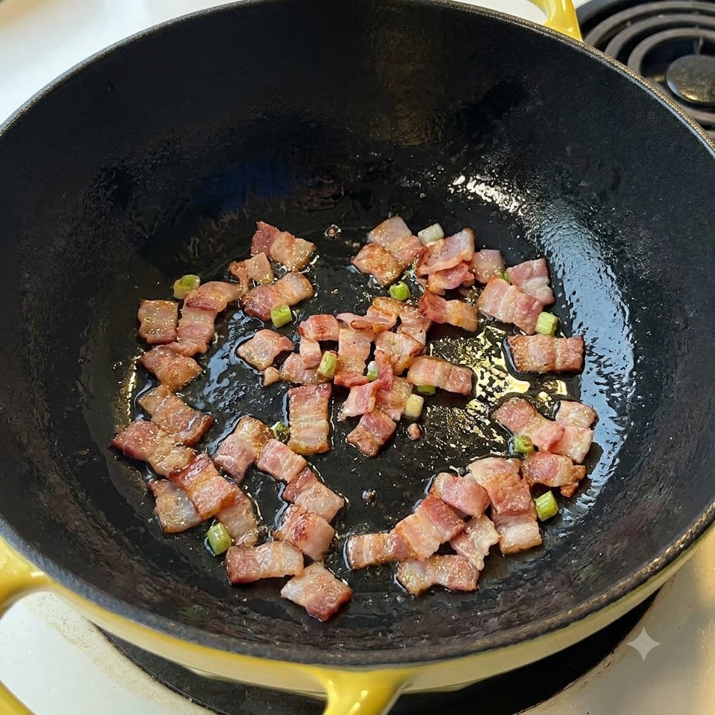 Des morceaux de bacon grésillant et frisant dans une poêle foncée.