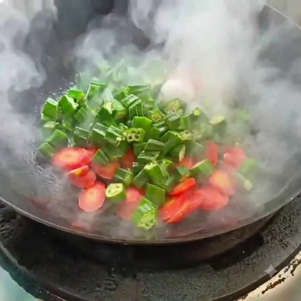 Rondelles de gombo et de carotte sautées dans un wok chaud avec de la vapeur montante.