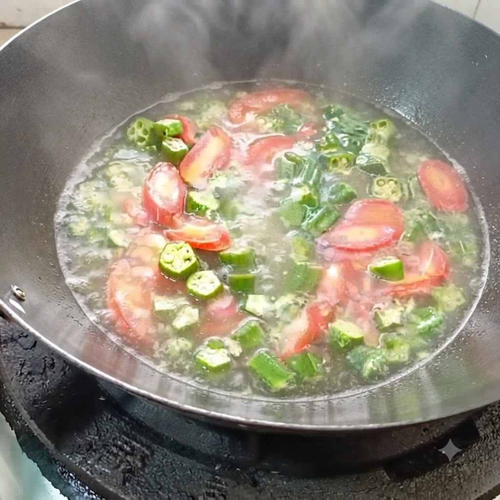 De leau bouillante versée dans le wok avec les légumes sautés.