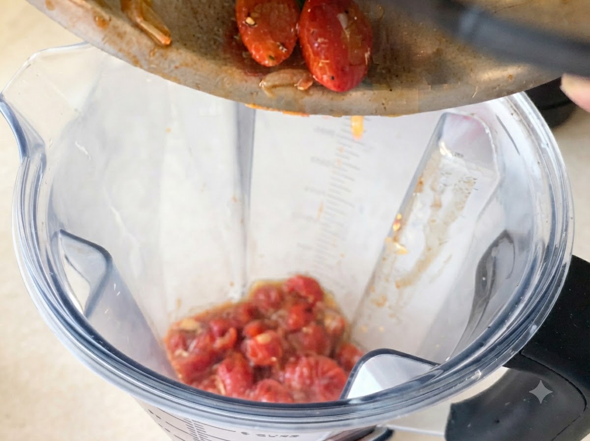 Une sauce tomate riche et rouge versée dans une poêle contenant lail et le piment dorés.