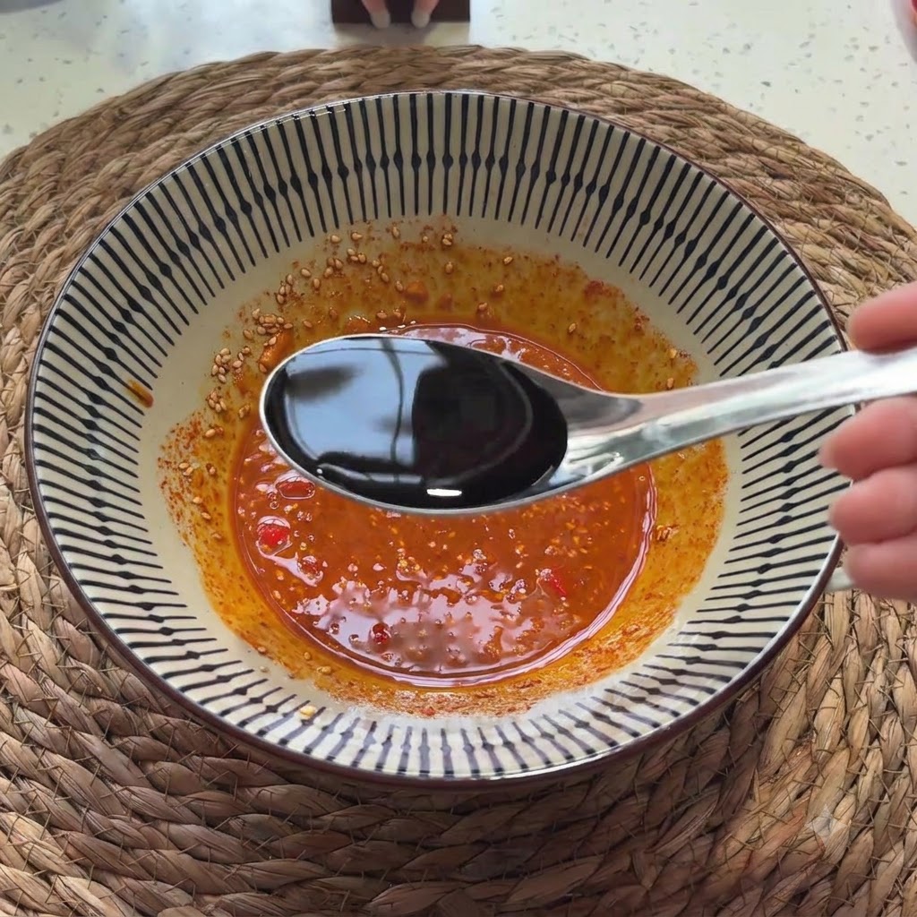 Sauce soja claire versée dune cuillère dans le mélange de sauce assaisonnée.