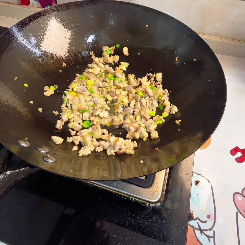 Viande hachée et aromates sautés dans un wok.