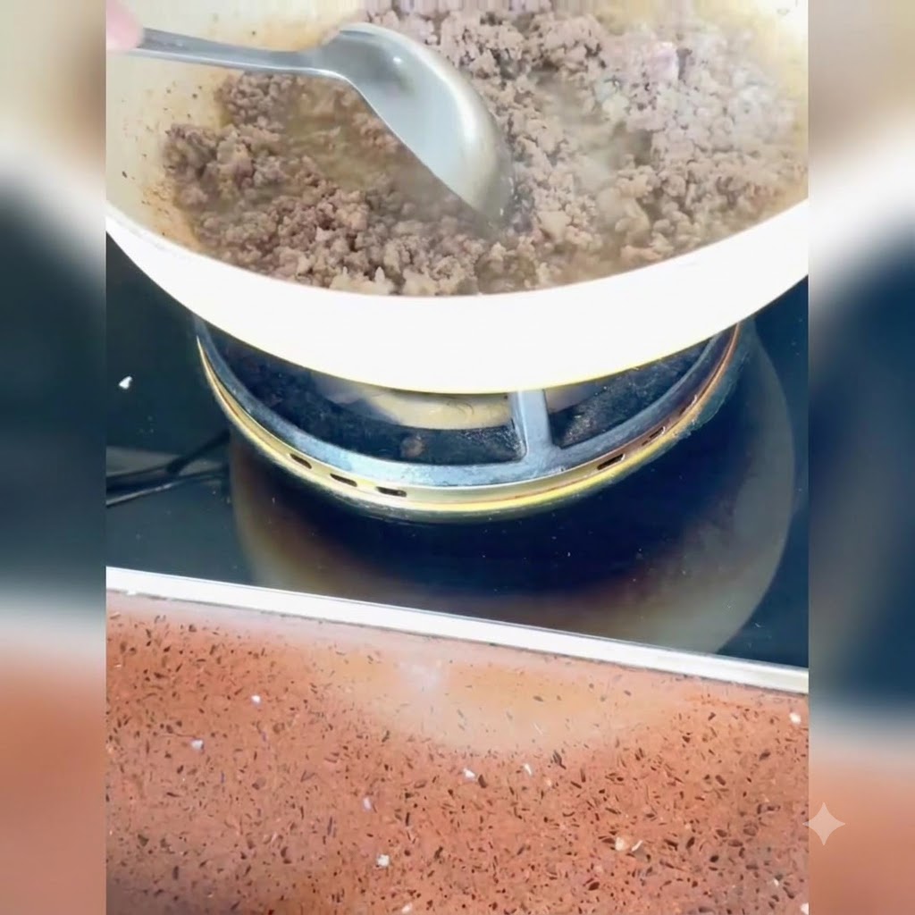 Oignons nouveaux, gingembre et ail émincés mélangés à la viande cuite dans la poêle.