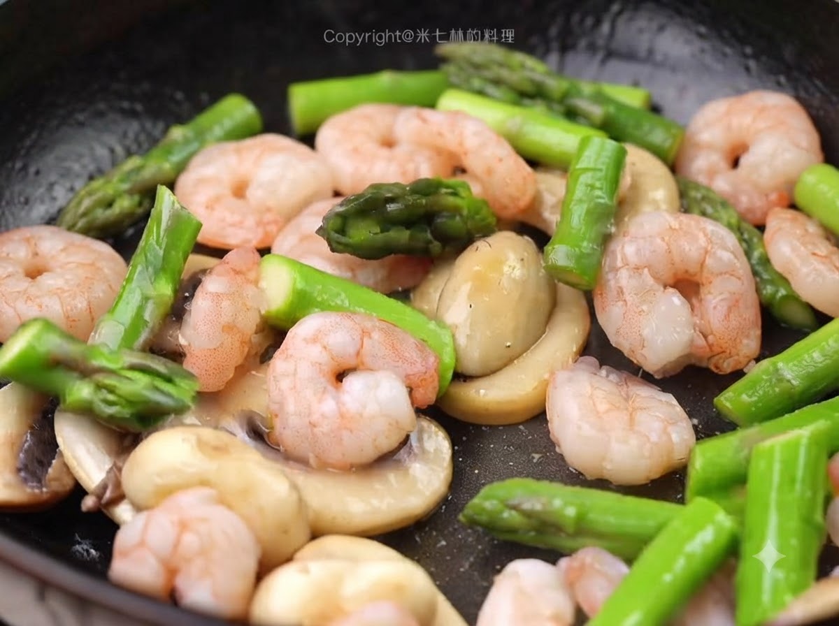 Morceaux de crevettes et dasperges vertes préalablement blanchis ajoutés dans la poêle avec les champignons.