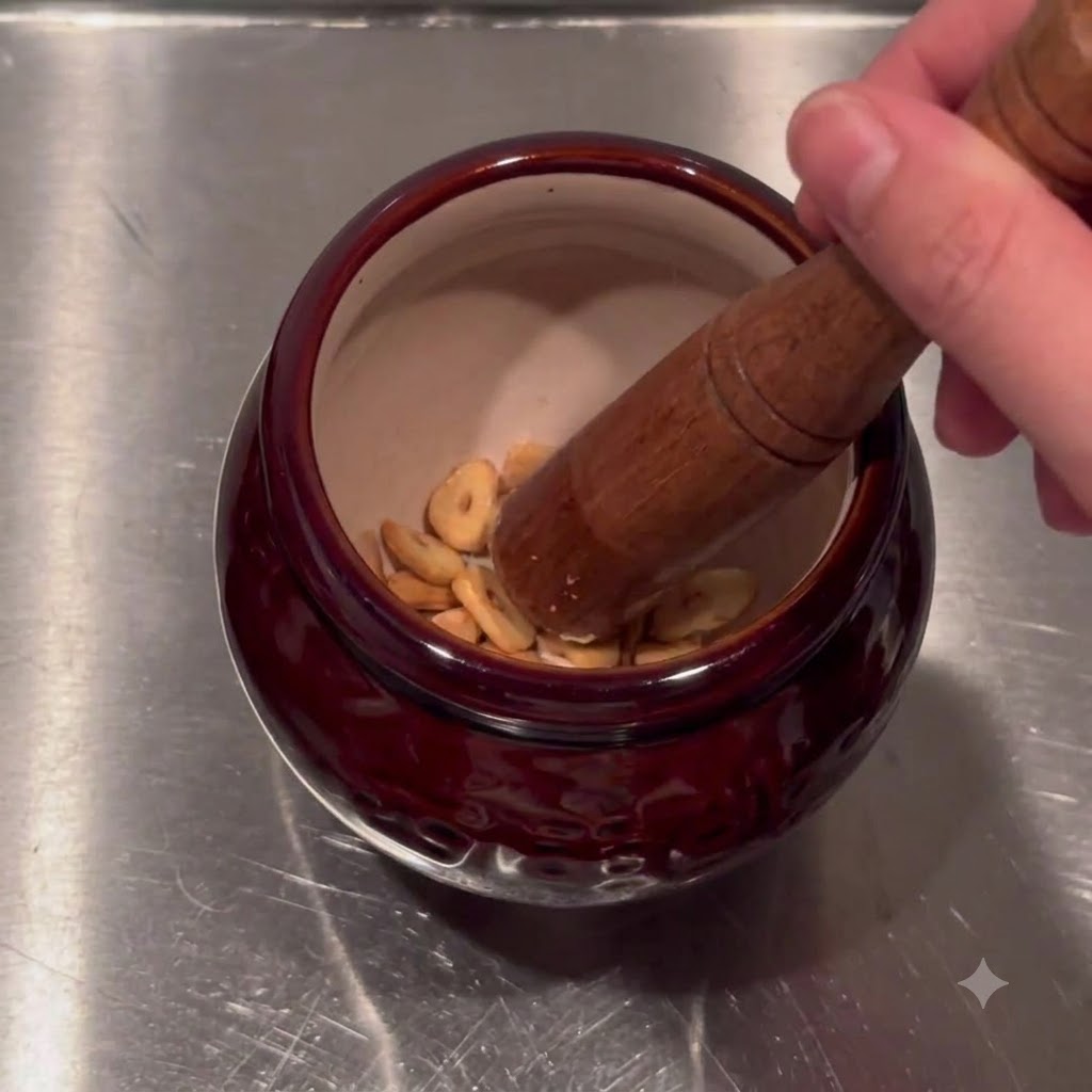 Chips dail frit de différentes nuances placées à lintérieur dun bol de mortier en céramique rouge foncé.