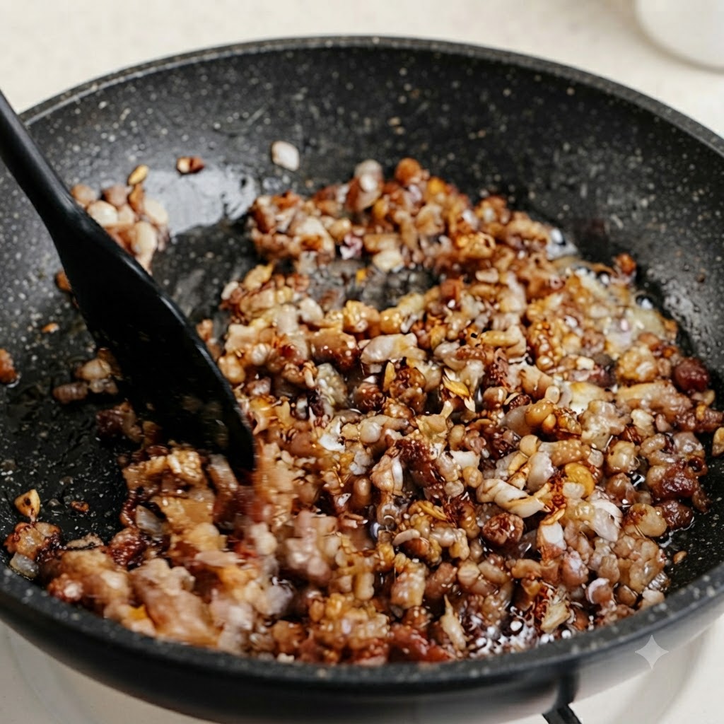 Tiges de ciboule et de ciboulette vertes hachées mélangées dans une poêle de viande hachée assaisonnée.