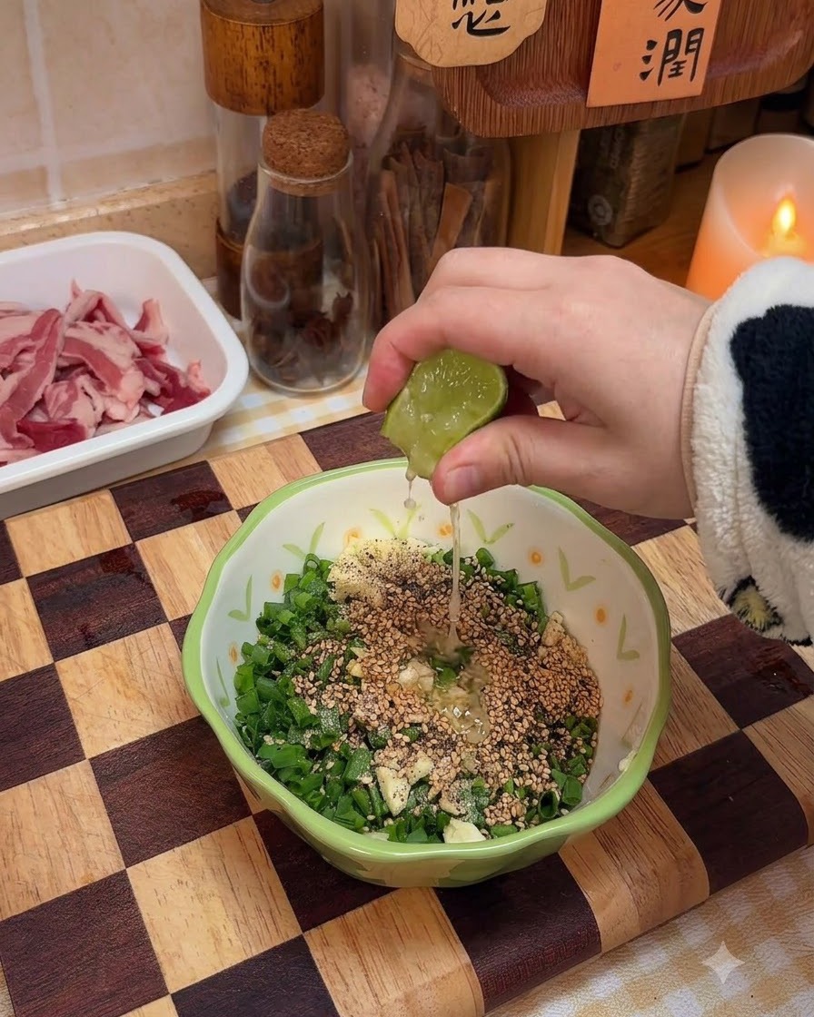 Du jus de citron vert frais pressé directement dans le bol contenant les ingrédients de la sauce aux oignons nouveaux.