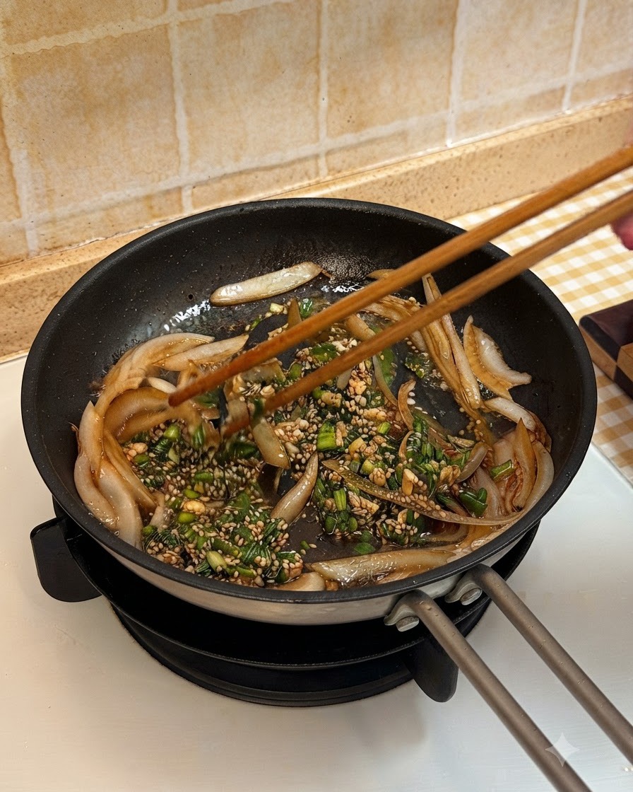 Des tranches de bœuf cuites ajoutées dans la poêle et mélangées avec les oignons et la sauce à laide de baguettes en bois.