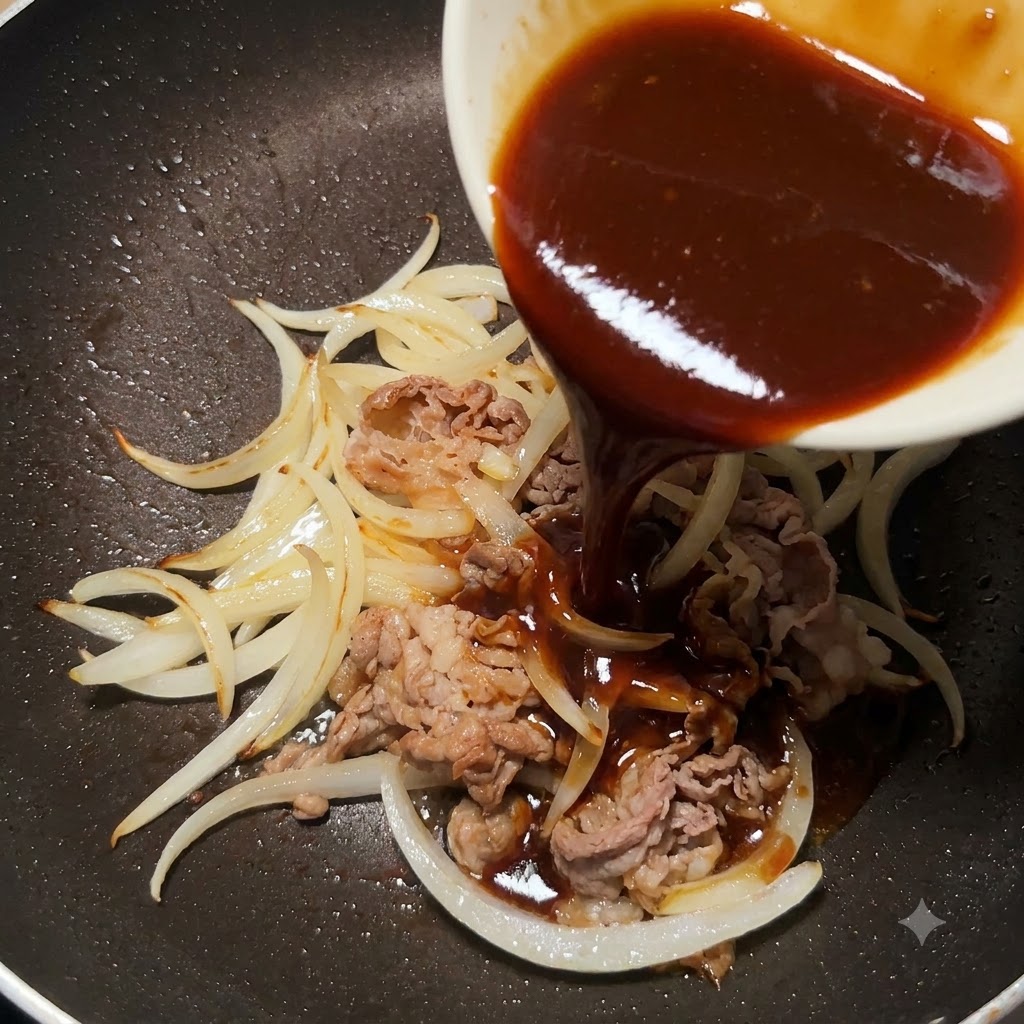 De la sauce teriyaki épaisse versée dun petit bol blanc dans une poêle contenant du bœuf émincé cuit et des oignons tranchés.