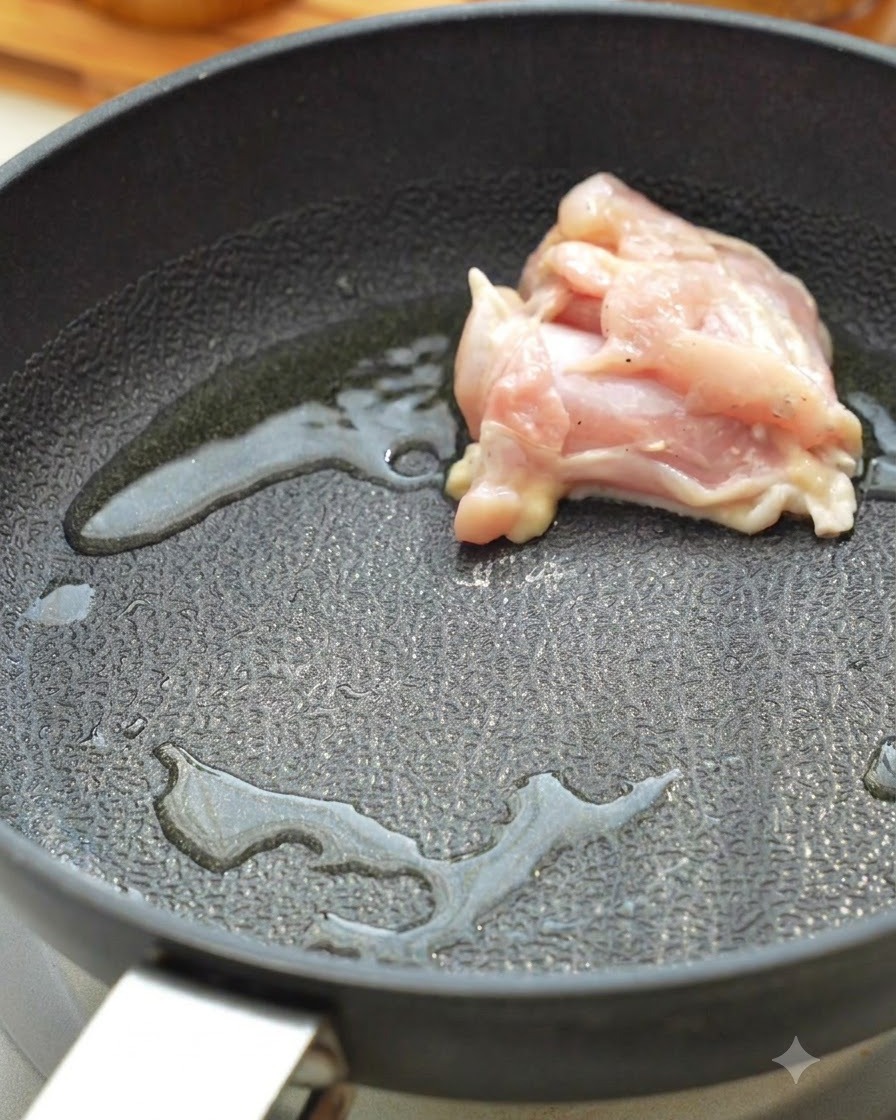 Morceaux de cuisse de poulet cru en train de saisir dans une poêle chaude avec de lhuile.
