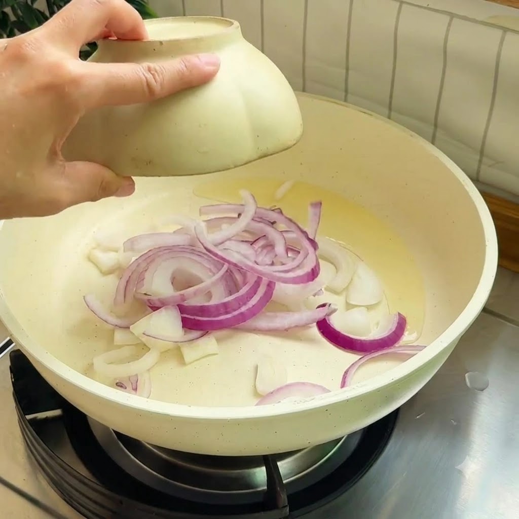 Des lanières doignon rouge sautant dans une poêle chaude avec de lhuile de cuisson.
