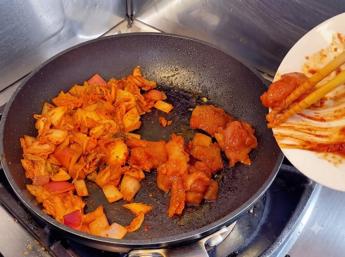 Utilisation de baguettes pour faire glisser des morceaux de poulet cru mariné dune assiette blanche dans une poêle à côté du kimchi et des oignons sautés.