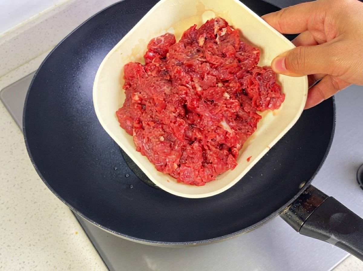 Bœuf haché en train dêtre sauté dans une poêle chaude avec de lhuile.