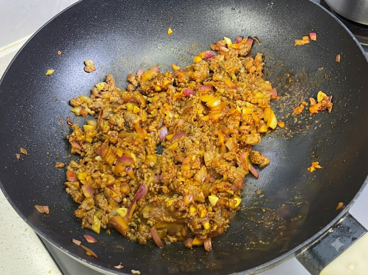 Lait incorporé dans la sauce au curry et à la viande à lintérieur de la poêle.