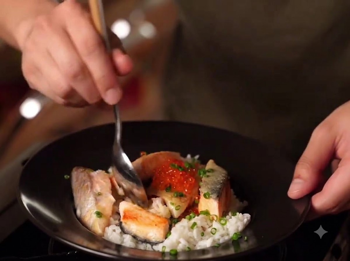 Gros plan sur un bol doyakodon de saumon au miso terminé avec du riz, des morceaux de saumon saisis, des œufs de saumon et des oignons verts.
