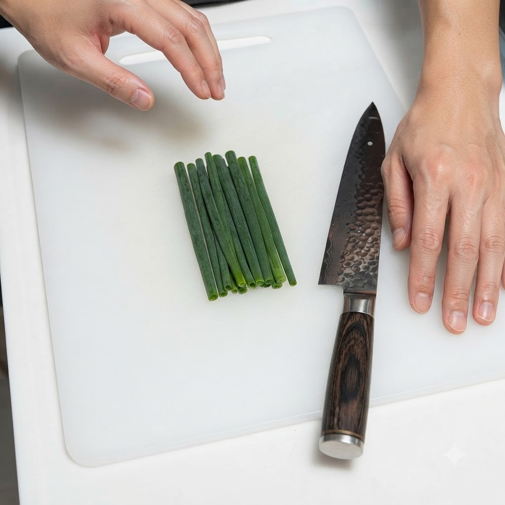 Une botte doignons verts soigneusement disposés à côté dun couteau de cuisine sur une planche à découper blanche.