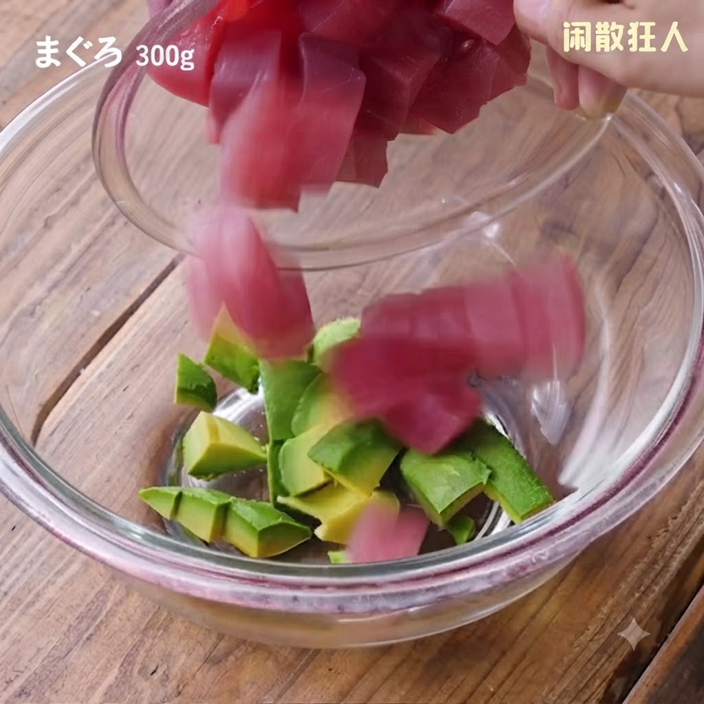 Des cubes de thon frais versés dun petit récipient dans le bol en verre contenant lavocat.