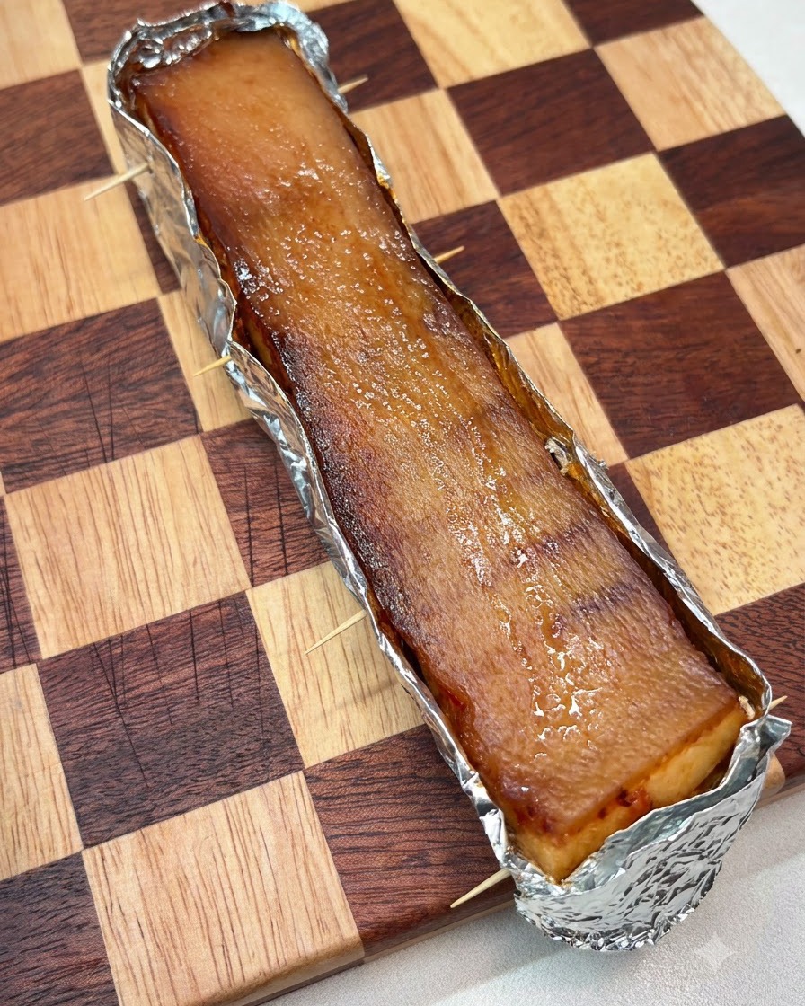 Une couche épaisse de gros sel étalée uniformément sur la surface de la peau du porc enveloppée daluminium.