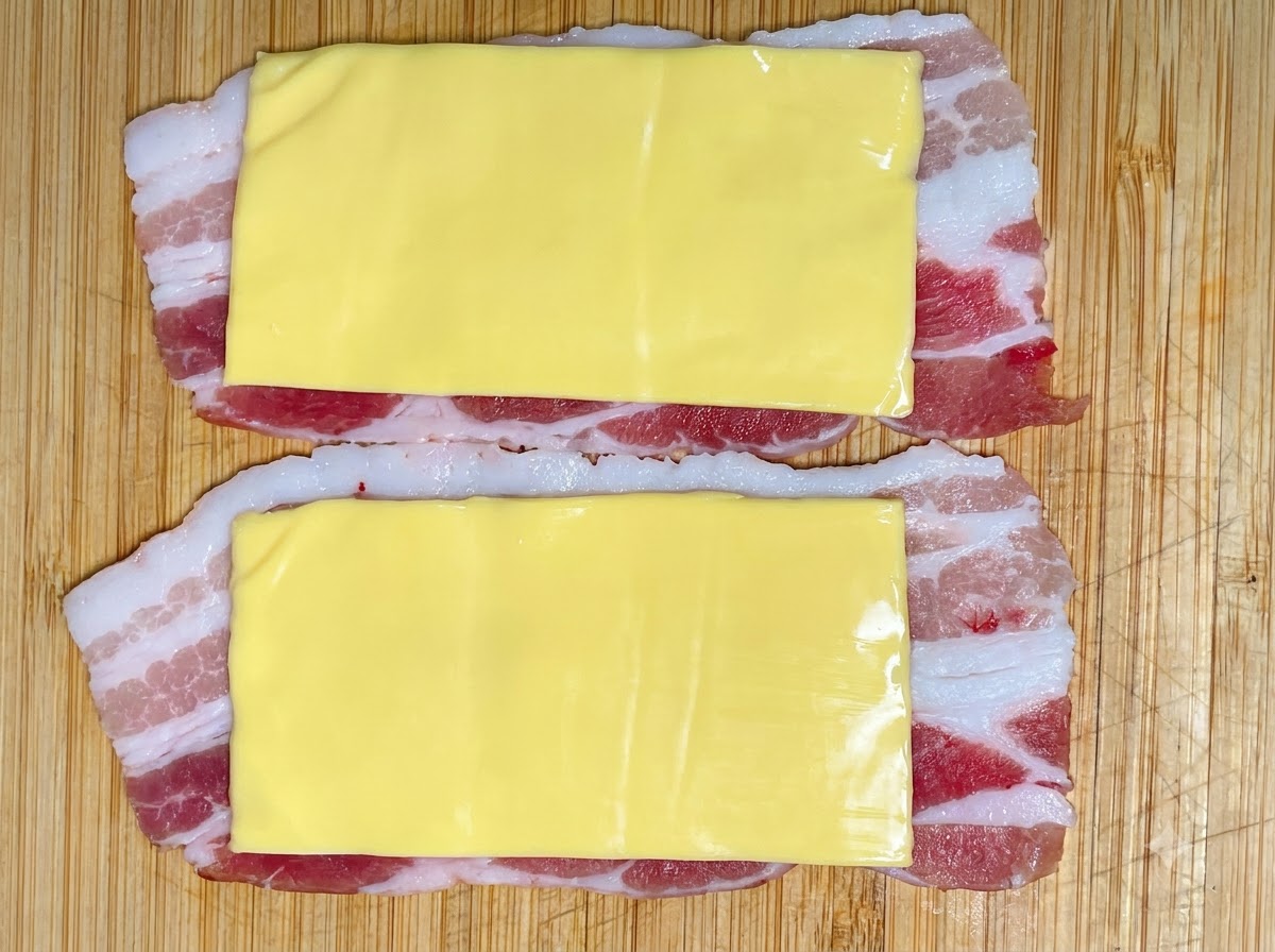 Une portion de pâte de crevettes pressée à partir dune poche à douille sur les couches de fromage et de porc.
