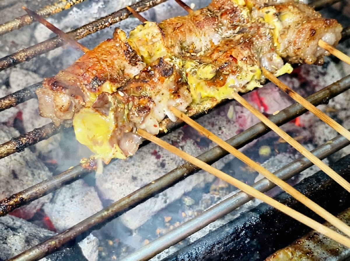 Graines de sésame saupoudrées sur le dessus des rouleaux de viande grillés.