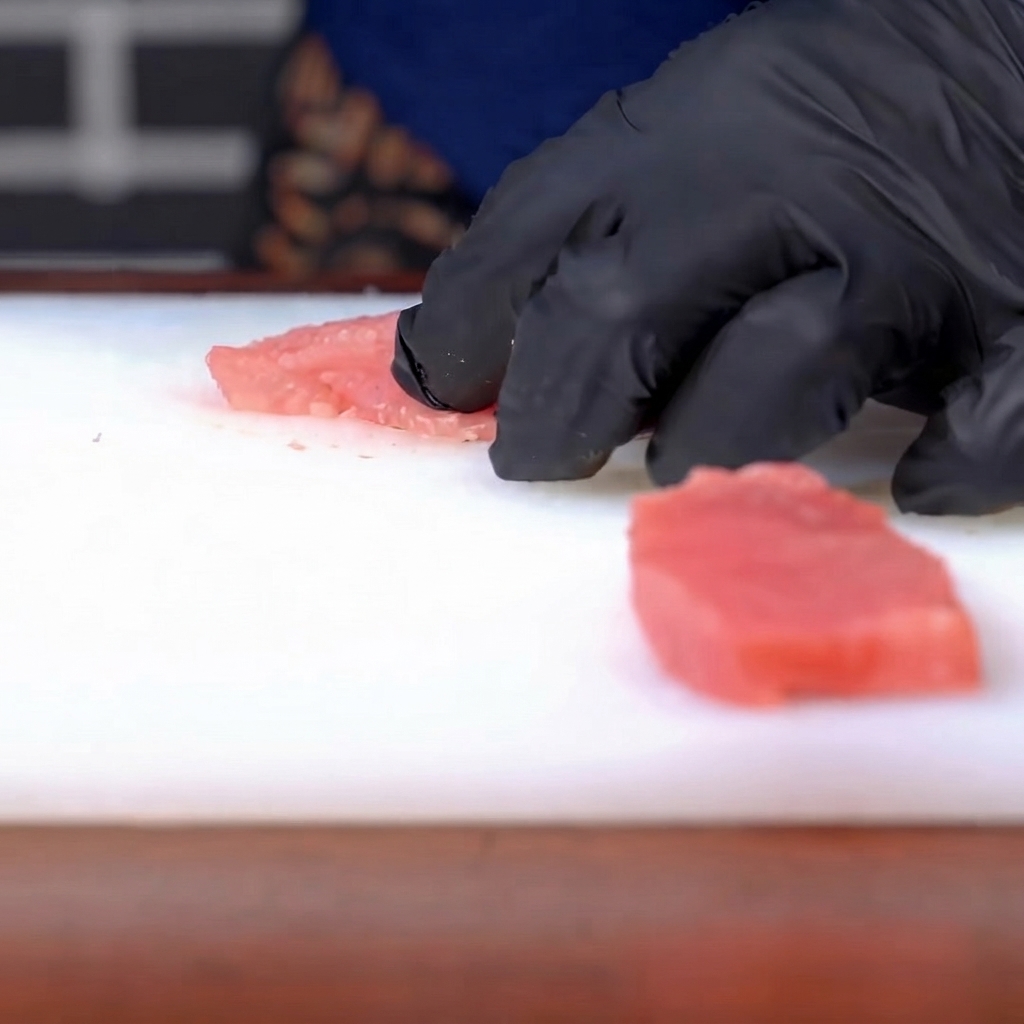 Du sel et du poivre saupoudrés sur une côte de porc crue et assaisonnée.
