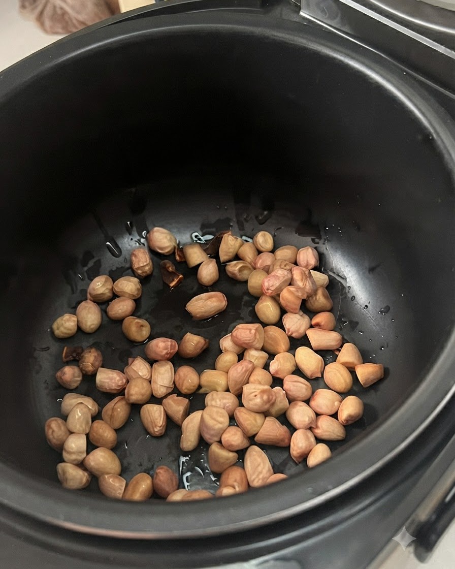 Cacahuètes pré-trempées éparpillées au fond dun autocuiseur ou dune mijoteuse électrique noire.