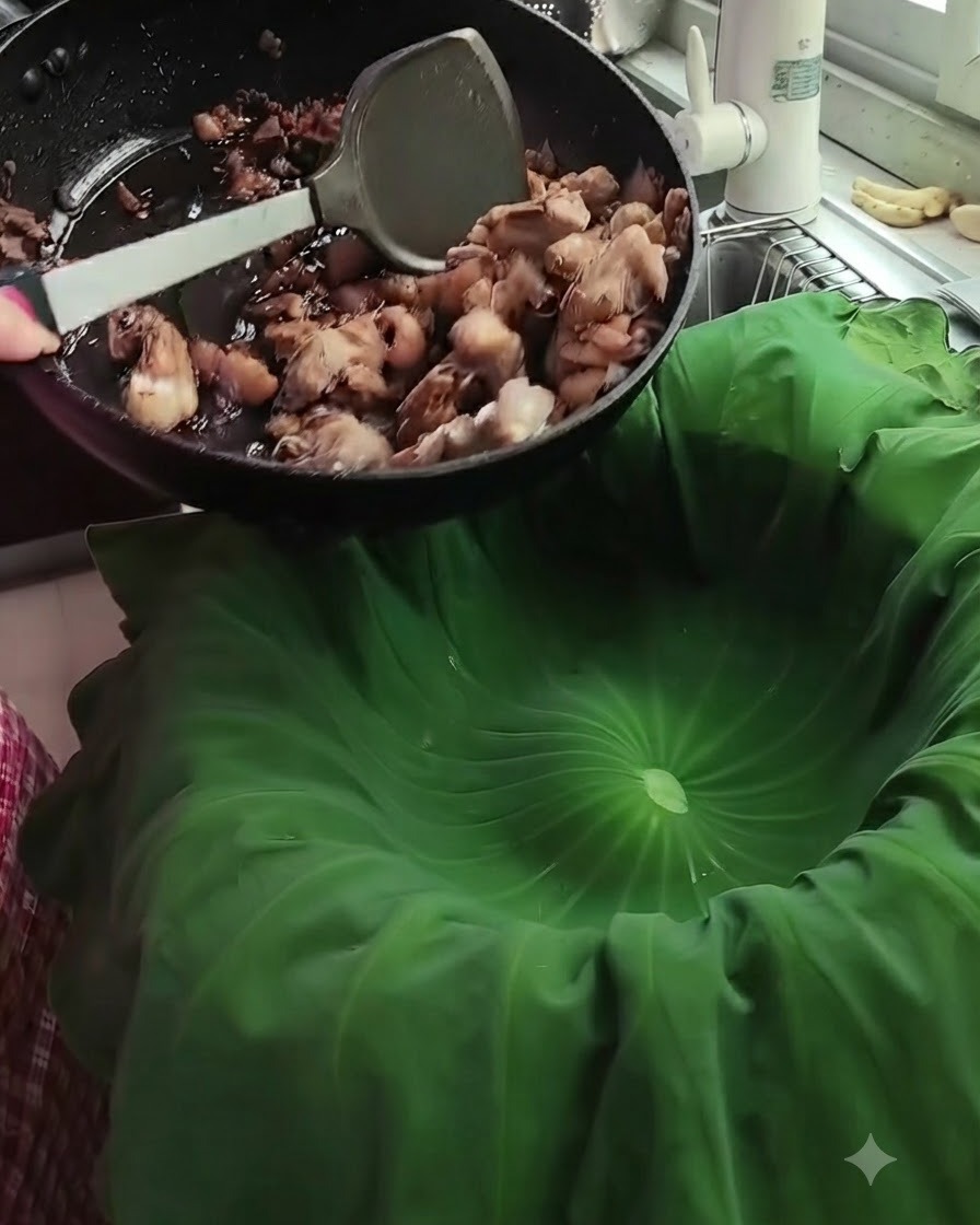 Morceaux de porc sautés versés depuis une poêle noire vers une grande feuille de lotus verte disposée dans un panier vapeur.