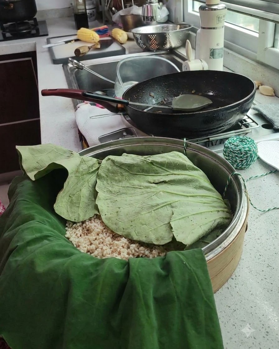 Paquet de feuille de lotus refermé dans un panier vapeur avec de la ficelle de cuisine verte et blanche à proximité.