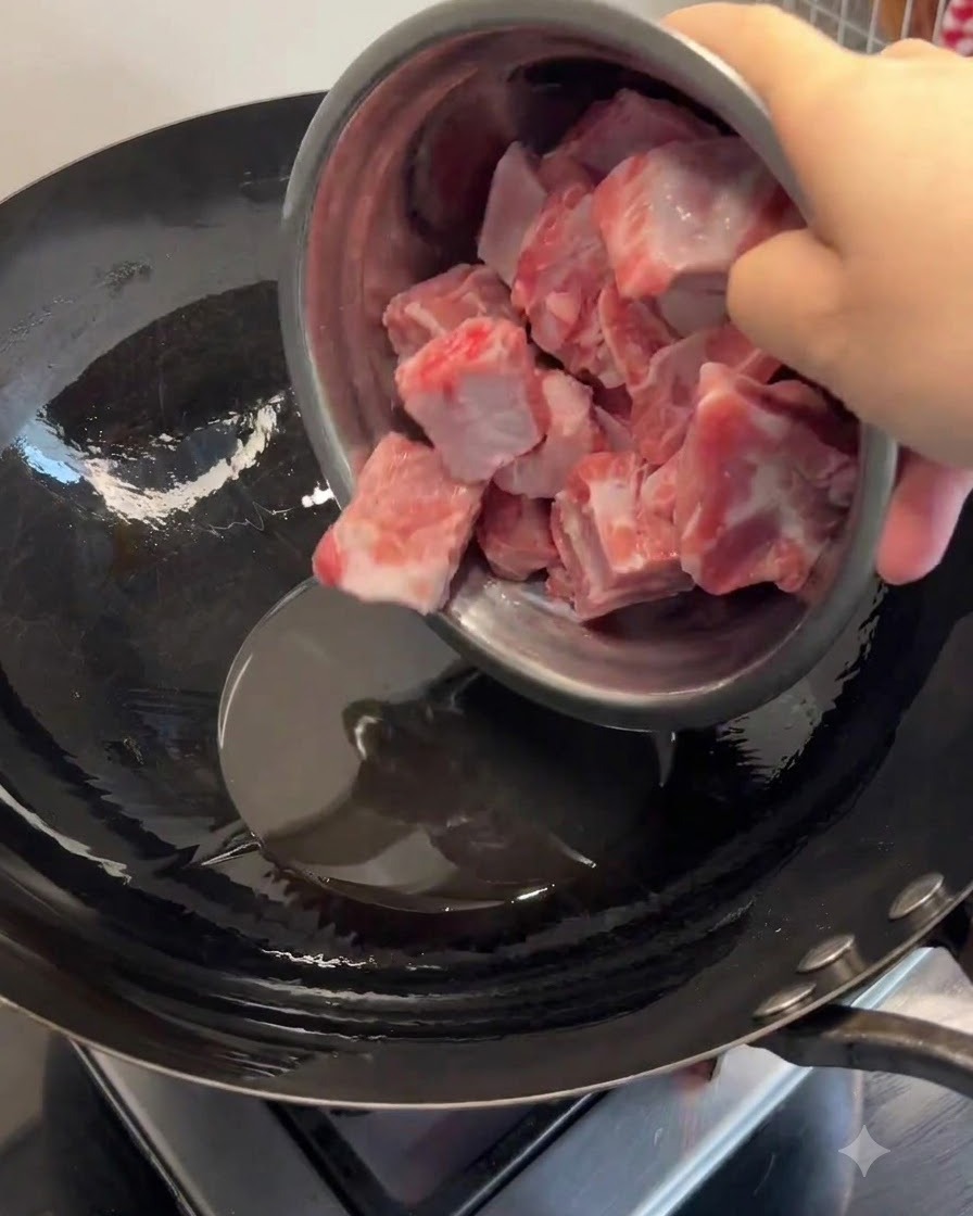 Des côtes de porc ajoutées au saindoux fondu dans un wok chauffé et sautées jusquà ce quelles soient dorées.