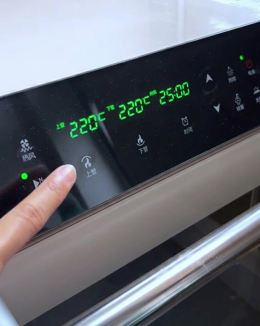Panneau de commande du four affichant des réglages de température de 220°C pour les éléments chauffants supérieur et inférieur.