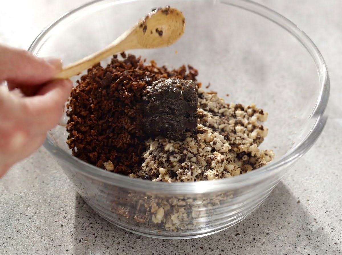 Pâte de truffe et champignons hachés mélangés soigneusement dans un bol en verre avec une cuillère en bois.