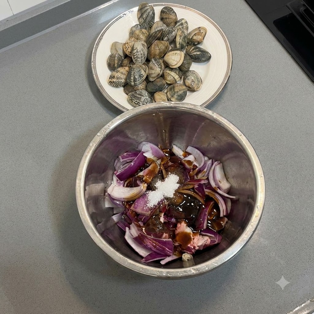 Morceaux de bœuf et oignons rouges mélangés avec des marinades dans un bol en métal à laide dune main gantée.