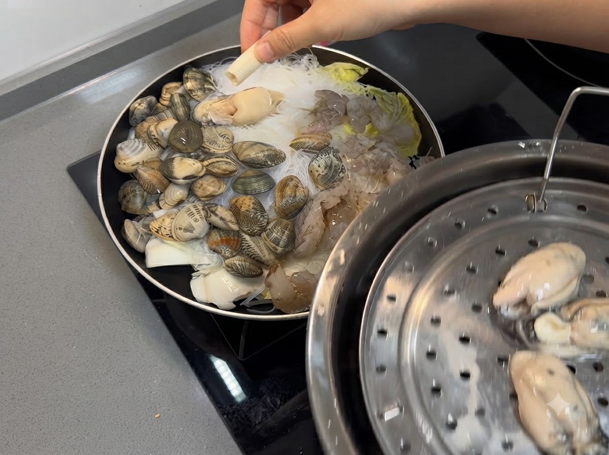 Crevettes et huîtres fraîches placées sur le mélange de fruits de mer et de nouilles dans la poêle.