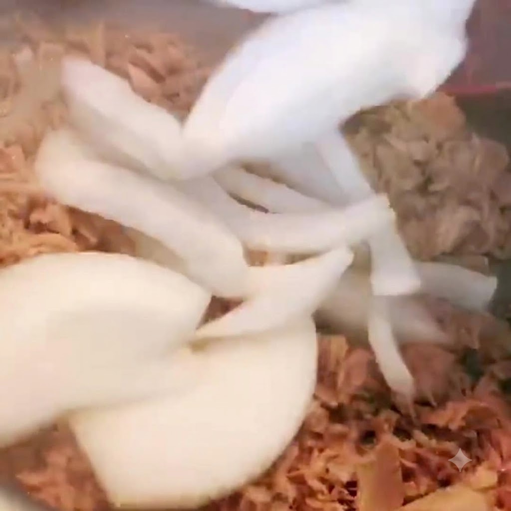 Oignons tranchés ajoutés dans la casserole contenant le thon et mélangés.