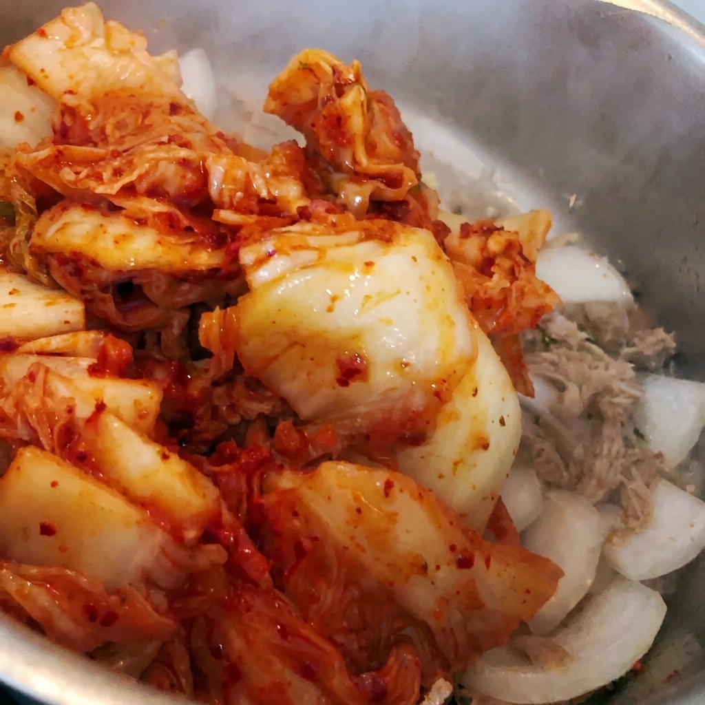 Kimchi haché jeté dans la casserole avec les ingrédients existants.