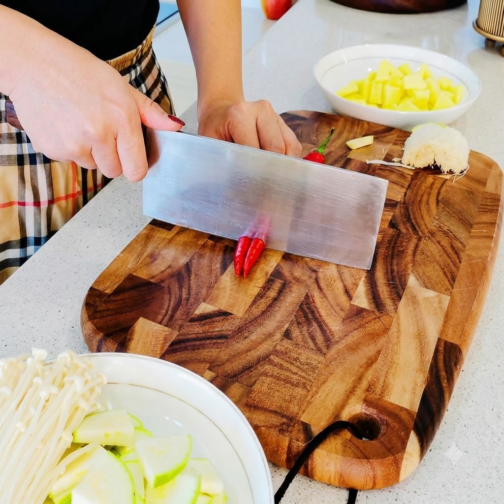 De petits piments rouges coupés en petits morceaux fins sur une planche à découper en bois.