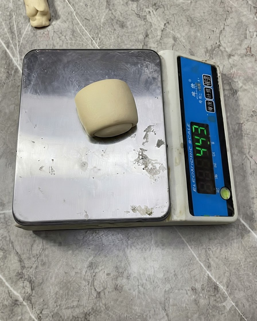 Une petite boule de pâte placée sur une balance de pesage numérique électronique.