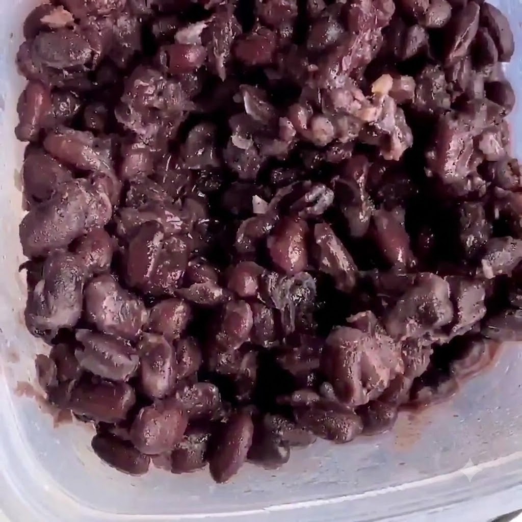 Haricots noirs cuits à lintérieur dun récipient en plastique prêts à être écrasés.