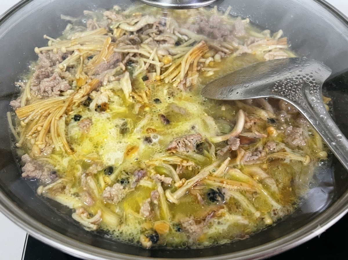 Mélange liquide de fécule de patate douce versé dun verre mesureur dans le wok.
