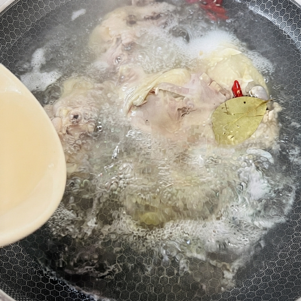 Une casserole remplie de bouillon de poulet bouillant, dépices et dune feuille de laurier mijotant sous la chaleur.