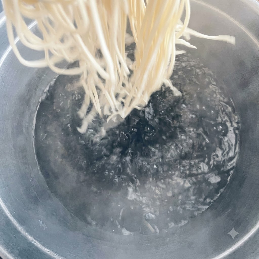 Des nouilles jetées dans une grande casserole deau bouillante.