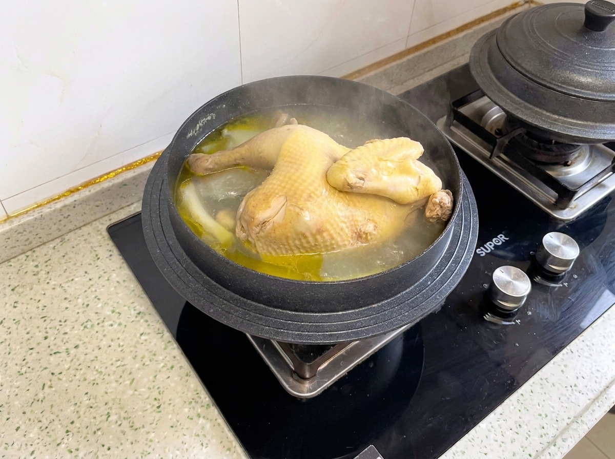 Un poulet entier cuit mijotant dans une casserole avant dêtre coupé en morceaux.