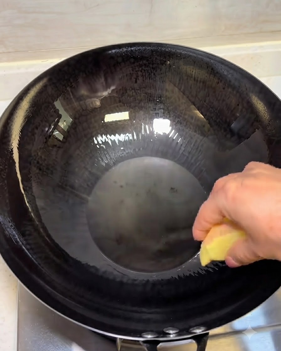 Tranches de gingembre frisant dans lhuile chaude dans un wok sombre.
