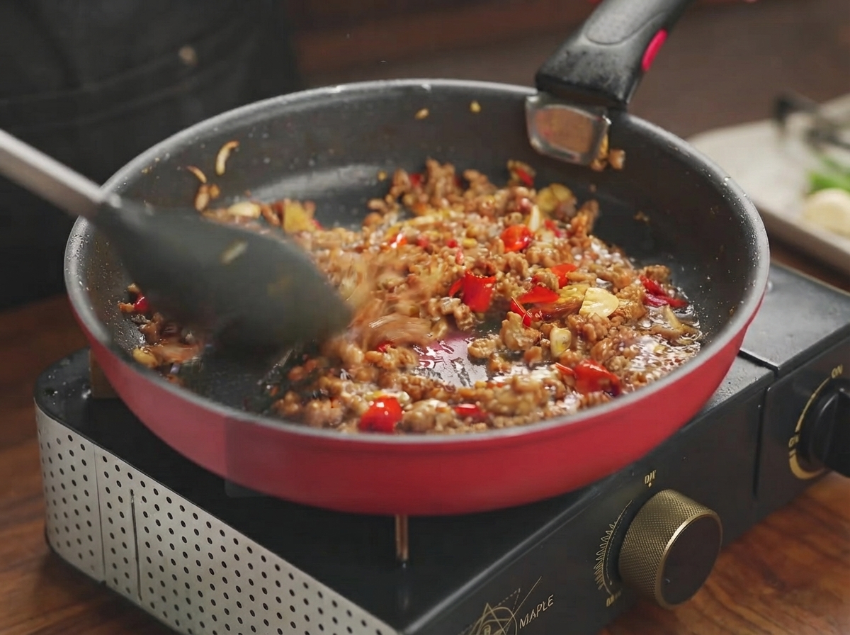 Mélange de porc mijotant et absorbant la sauce savoureuse dans une poêle.