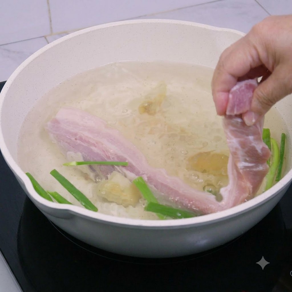 Morceaux de poitrine de porc plongés dans une casserole deau bouillante.