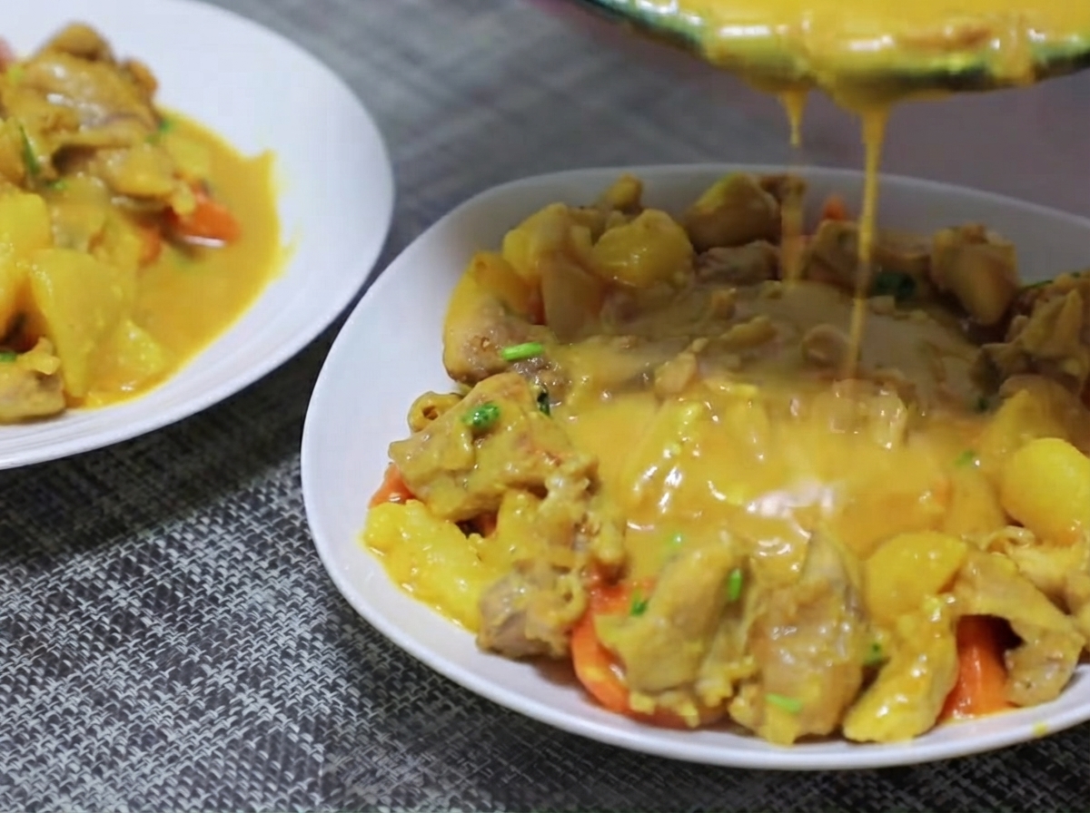 Morceaux de pommes de terre et de carottes ajoutés dans la poêle et sautés avec la base de curry.
