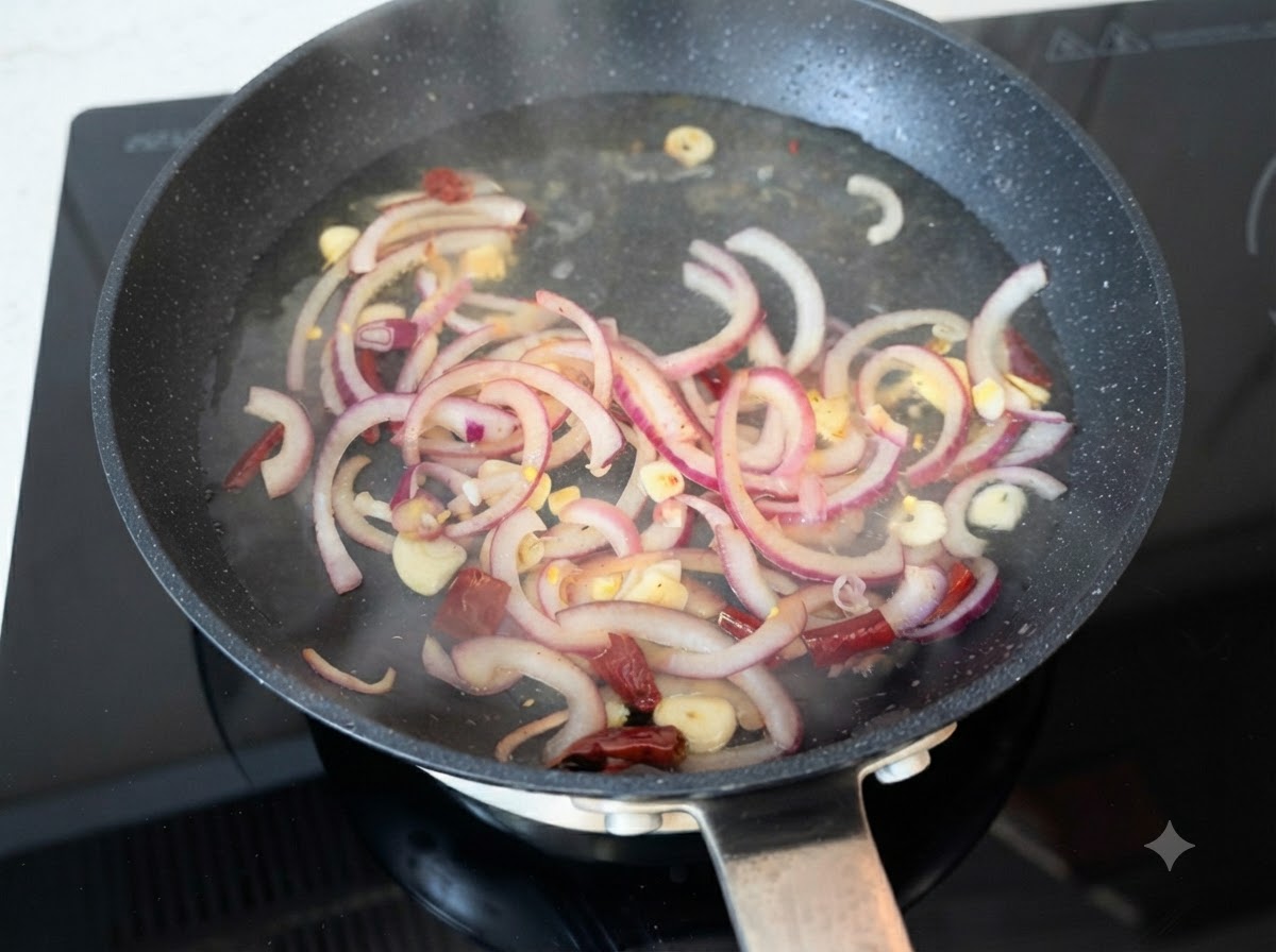 De leau chaude versée sur des tranches doignon rouge sautées, de lail et des piments dans une poêle.