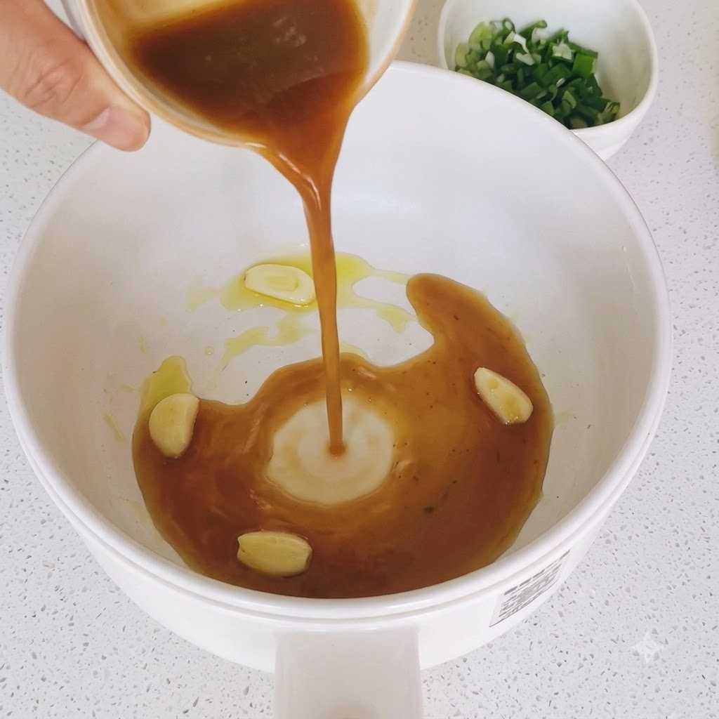 Mélange de sauce brune versé dans une poêle avec des tranches dail sautées.