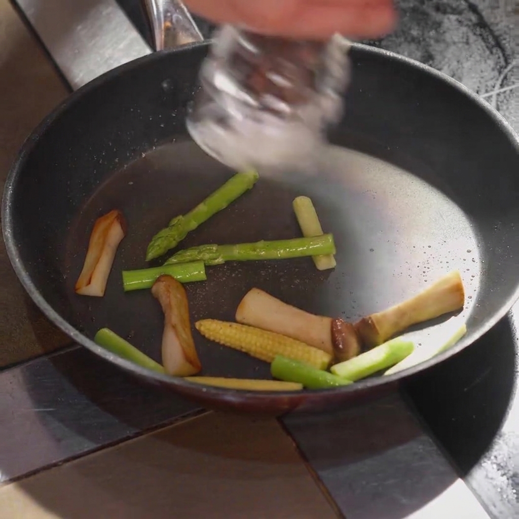 Du sel assaisonné sur les légumes à lintérieur de la poêle de cuisson.